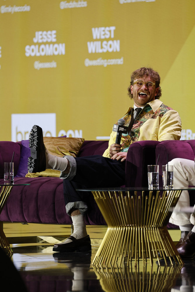 West Wilson laughing and kicking his feet at BravoCon 2025 