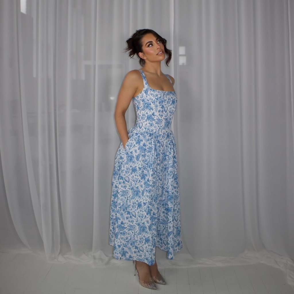 Katie Salmon in a blue and white dress, looking up at the ceiling