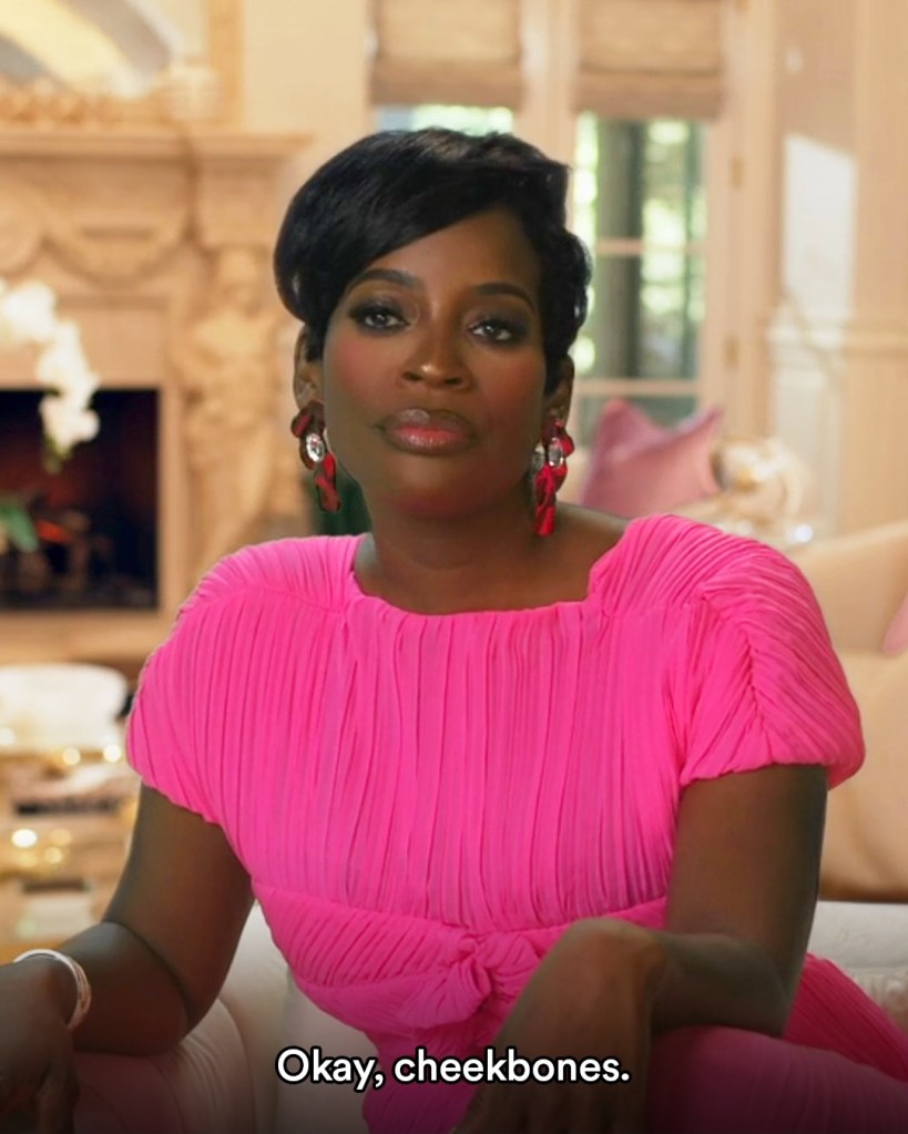 Shamea Morton in a pink dress saying, "Okay, Cheekbones" in a confessional interview on Real Housewives of Atlanta
