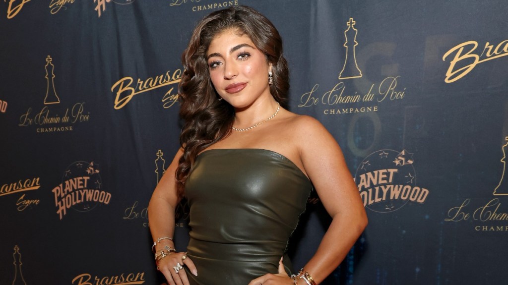 Melania Giudice standing in a green dress with her hands on her hips
