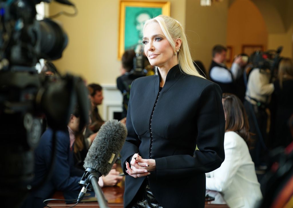 Erika Jayne in a black suit giving an interview at Capitol Hill