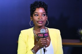 Shamea Morton in a yellow blazer looking sideways and holding a microphone