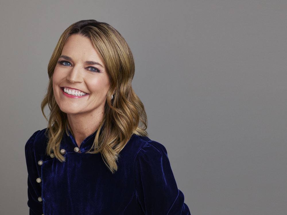 Savannah Guthrie headshot, smiling in a blue top in front of a gray background
