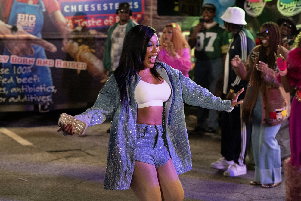 K. Michelle in denim shorts and a jacket dancing in the street 