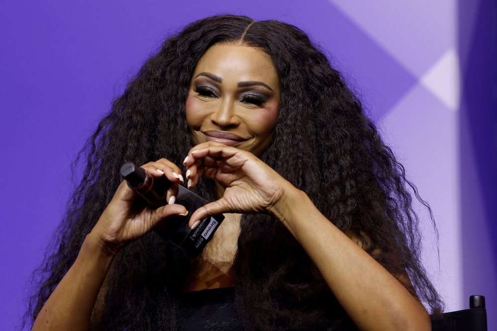 Cynthia Bailey making heart hands on stage at BravoCon 2025