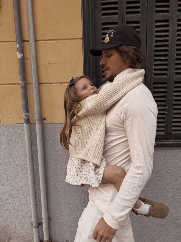 Jake Hall with his daughter, River, holding onto him 