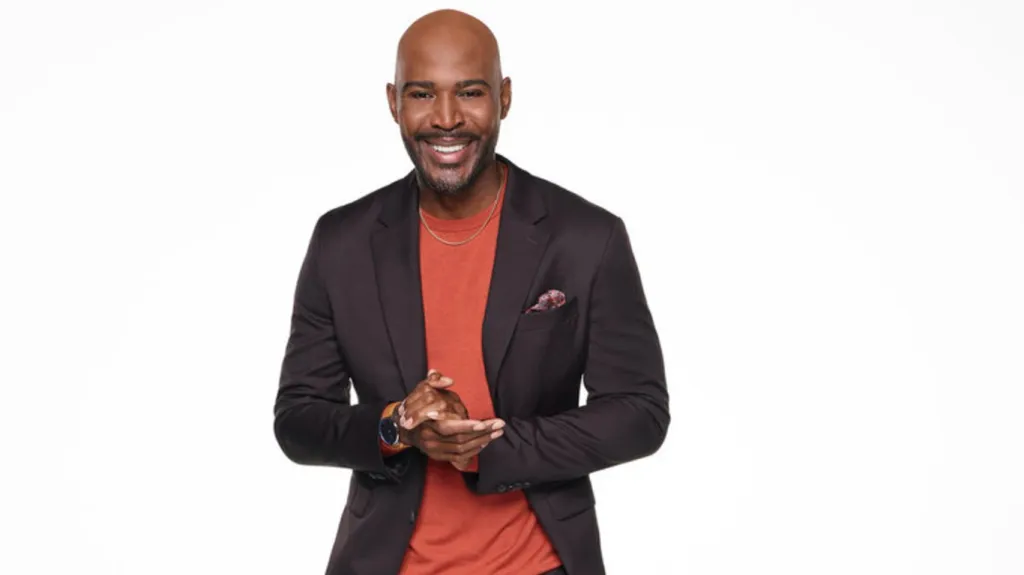 Karamo Brown in a red shirt and black suit for Season 3 of Karamo
