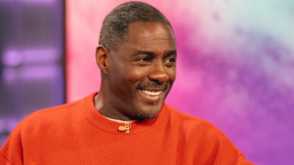 Idris Elba in a red sweater on the Kelly Clarkson Show