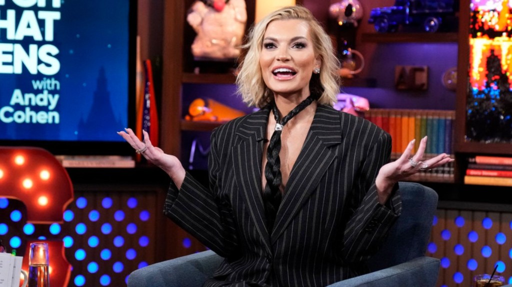 Lindsay Hubbard in a pin striped suit and horse hair tie with her harms out on Watch What Happens Live