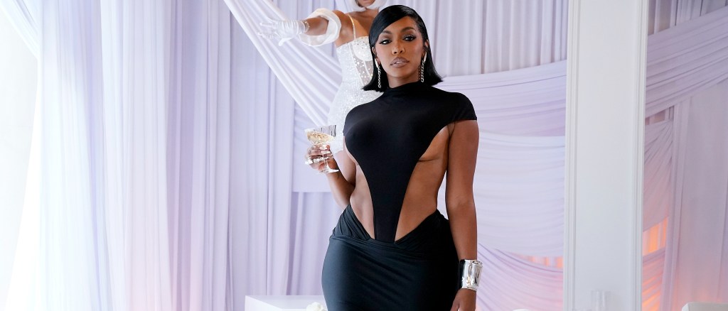 Porsha Williams holding a glass wearing a black dress on RHOA Season 17