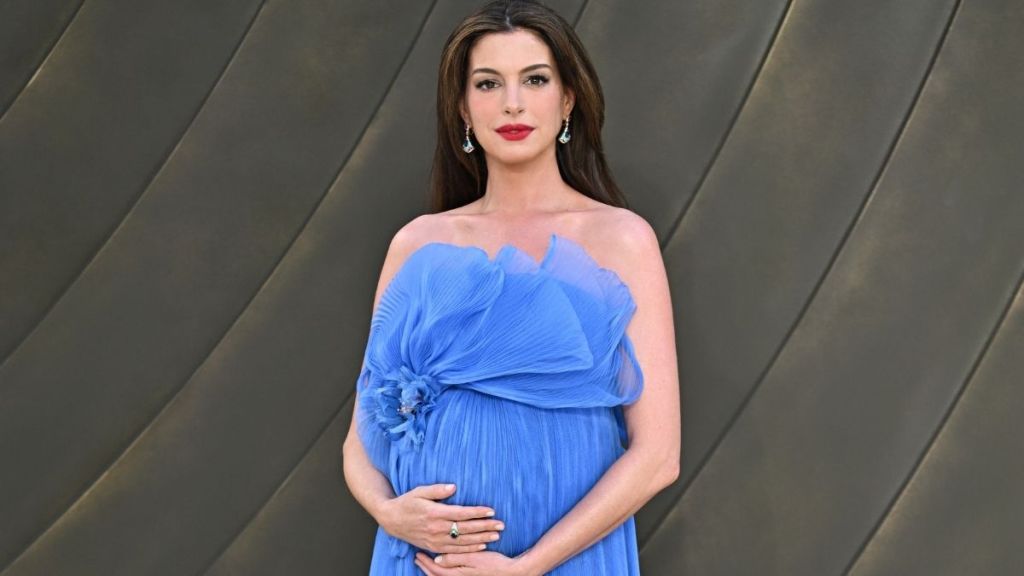 Pregnant Anne Hathaway Cradles Her Baby Bump at ‘The Odyssey’ Premiere